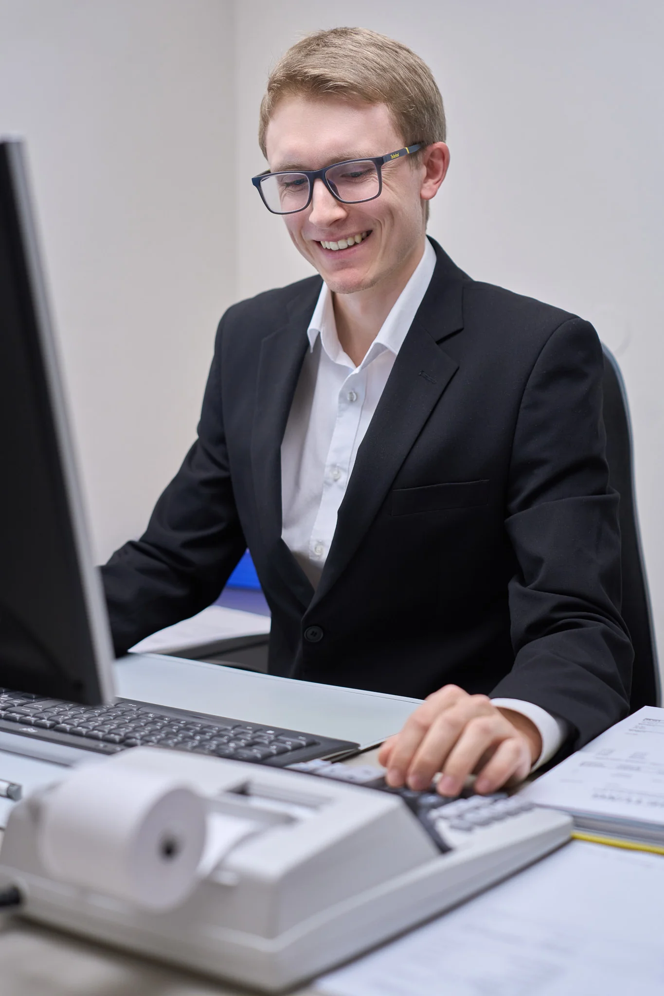 Kollege mit blauer Brille am Computerarbeitsplatz