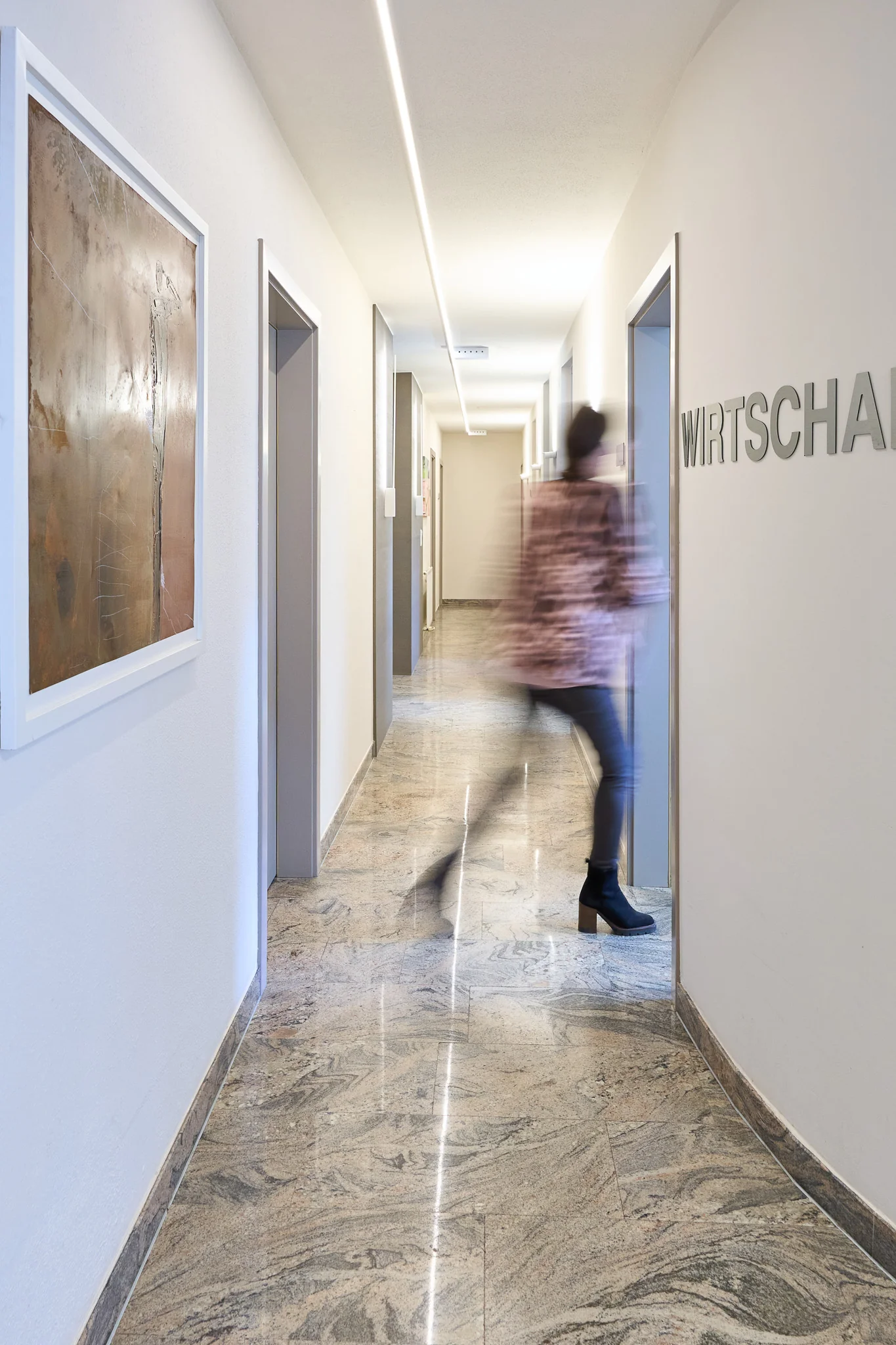 Heller Kanzleiflur mit einer in Bewegung unscharfen Person